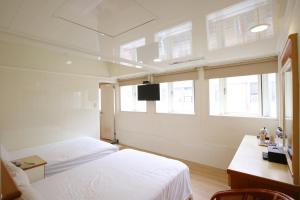 罗东镇幼狮大饭店的一间卧室设有两张床、一张桌子和窗户。