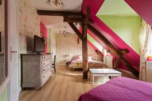 RangChambres d'hôtes Les Charmettes的卧室设有紫色和粉红色的墙壁和一张床