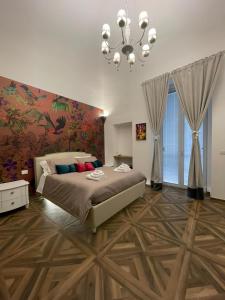 曼弗雷多尼亚Relais del Corso的一间卧室配有一张大床和一个吊灯。
