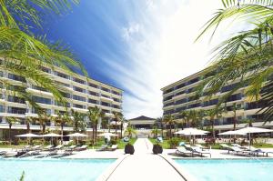 石垣岛全日空石垣岛洲际度假酒店的一个带椅子和遮阳伞的游泳池的度假酒店