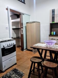 伊利亚贝拉Patricio's Chalés Ilhabela的厨房配有桌子和冰箱