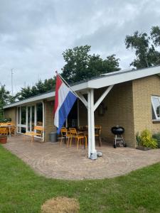 欣德洛彭De Vier Winden的一个带旗帜和桌椅的庭院