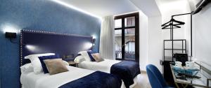 毕尔巴鄂Pension Ama Bilbao的酒店客房设有两张床和窗户。