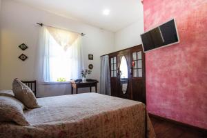 迈里波朗Refúgio Pasárgada Guest House的卧室配有一张床,墙上配有电视。