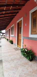 伊利亚贝拉Patricio's Chalés Ilhabela的红色的建筑,有木门和鲜花