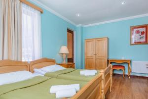 梅斯蒂亚Hotel Lileo的卧室设有两张床铺和蓝色的墙壁
