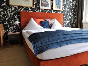 施特拉尔松德祖尔法赫布鲁克旅馆的一张带蓝色被子和枕头的床