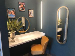 绍斯波特Waterfront Southport Hotel的浴室设有水槽、两面镜子和一把椅子