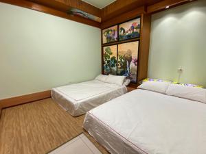 屏东县桥畔民宿的墙上画作的房间里设有两张床
