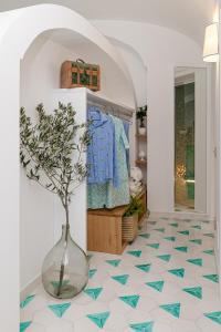 波西塔诺Petrea Lifestyle Suites的地板上一个植有植物的花瓶的房间