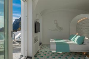 波西塔诺Petrea Lifestyle Suites的一间卧室设有一张床和一个阳台