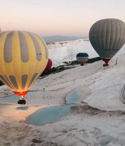 帕莫卡莱Hotel Goreme Sakura的三只热气球在一桶水上飞行