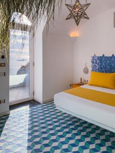 波西塔诺Petrea Lifestyle Suites的卧室配有一张蓝色和白色的床铺