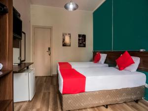 圣保罗MOVA 104 - Hotel Consulado Avenida Paulista的一间卧室配有一张带红色枕头的大床