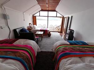 普诺Uros Lake Titicaca Lodge的带两张床的房间和客厅