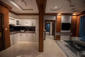 奈季兰Elite Najran的一间带白色橱柜的厨房和一间客厅
