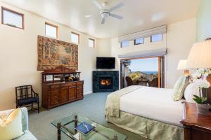 卡梅尔绿林狩猎旅馆的一间卧室配有一张床和一个壁炉