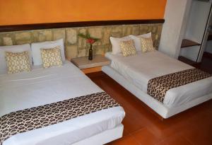 锡瓦塔塔内霍Hotel Casa Arena的两张睡床彼此相邻,位于一个房间里