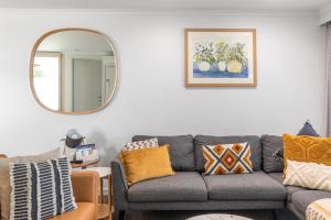 芒特甘比尔City Courtyard Two Apartment的客厅配有灰色的沙发和镜子