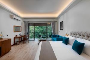 基图尔格勒Moksha at Kitulgala - Rainforest Boutique Hotel的一间卧室配有一张带蓝色枕头的大床