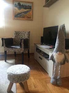 布尔泽策Sunčani Apartman的客厅配有电视和椅子