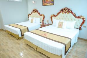 清化Khách Sạn Phượng Hoàng 3的蓝色墙壁客房的两张床