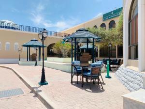 Al ‘Aqar雅巴尔艾赫代尔酒店的一个带桌椅和遮阳伞的庭院