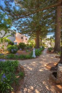 卢斯Quinta Paraiso da Mia - Two bedroom apartment的院子里树木和花的砖路