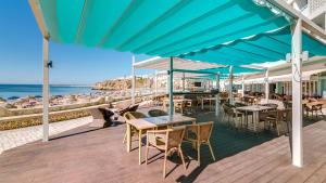阿尔布费拉Hotel Sol e Mar Albufeira - Adults Only的一个带桌椅的甲板和海滩