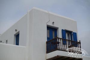 锡基诺斯岛Comfy Room with Adorable View的白色的建筑,设有蓝色的门和阳台