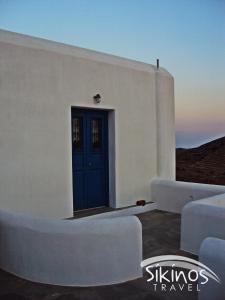 锡基诺斯岛Comfy Room with Adorable View的白色的建筑,设有蓝色的门和白色的沙发