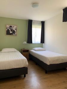 栋堡多姆堡之家公寓的一间卧室设有两张床和窗户。