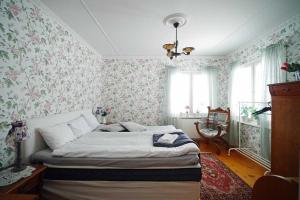 ÖverkalixVilla Sisu的一间卧室配有一张带花卉壁纸的床
