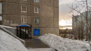 摩尔曼斯克Murmansk Discovery - Hotel Navigator的前面有一堆积雪的建筑物