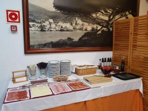 卡达克斯萨瓜尔达酒店的桌子上摆放着食物和盘子的桌子