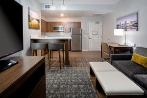 长滩Staybridge Suites - Long Beach Airport, an IHG Hotel的公寓客厅配有沙发和厨房