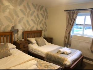 哈廷顿水壶&玻璃旅馆的一间卧室设有两张床和窗户。