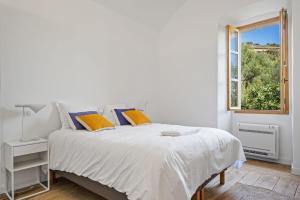 卡尔热斯Cargèse, appartement de charme surplombant le port的白色的卧室设有床和窗户