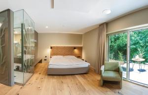 瓦登Hotel Weiherhof am Golfpark的一间卧室设有一张床和一个玻璃淋浴间