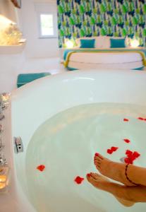 特罗佩阿Il Borghetto Creative Resort的人脚在红色心脏的浴缸里