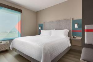 米尔堡avid hotels Fort Mill - Amusement Park, an IHG Hotel的卧室设有一张白色大床和一扇窗户。