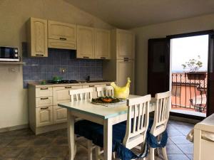 波萨达Sas Tilibbas-Ammentos Posada的一间带桌椅的厨房和一间带阳台的厨房