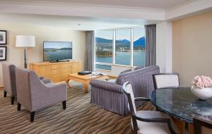 温哥华温哥华泛太平洋酒店的客厅配有桌椅和电视。