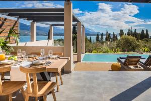 里科索翁Ionian Village的一间设有桌子并享有游泳池景致的用餐室