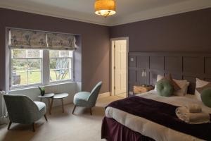 克雷盖拉希Craigellachie Lodge的一间卧室配有一张大床和一张桌子及椅子