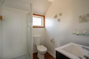 凯库拉尼考旅馆的浴室配有卫生间、淋浴和盥洗盆。