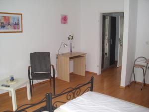 埃森卡萨玫瑰酒店的一间卧室配有一张床、一张桌子和一把椅子