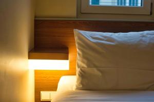 柏林柏林哈克市场便捷酒店的靠窗的带白色枕头的床