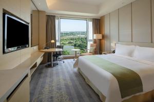 南阳Holiday Inn Nanyang, an IHG Hotel的一间酒店客房,设有一张大床和一个大窗户
