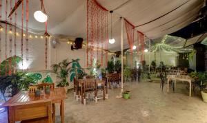 浦那Treebo Trend Ranjeet Shivaji Nagar的植物间里带桌椅的餐厅